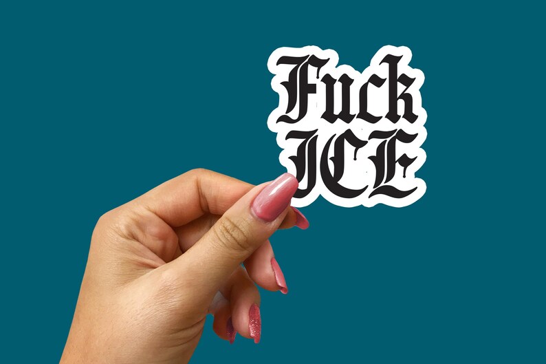 May include: A white sticker with the words "Fuck ICE" in a black gothic font. The sticker is held by a hand with pink nail polish against a teal background.
