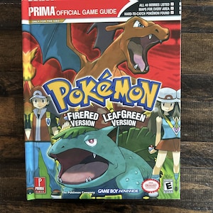 May include: A Prima Official Game Guide for Pokémon FireRed and LeafGreen versions. The cover features Charizard, Venusaur, and other characters. The guide includes maps, berry listings, and information on hard-to-catch Pokémon.