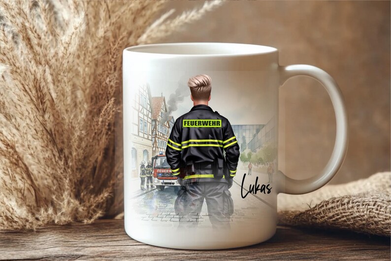 May include: White ceramic mug featuring a firefighter illustration. The design shows a firefighter in uniform with the word "FEUERWEHR" on the back. The mug also has the name "Lukas" written on it.