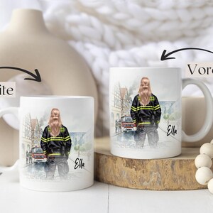 May include: White ceramic mug featuring a watercolor illustration of a firefighter in uniform, with the name "Ella" in script. The design includes a fire truck and a European town scene. The mug is displayed on a wooden surface.
