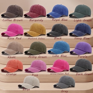May include: A collection of baseball caps in various colors, including coffee brown, burgundy, and royal blue. Each cap has a curved brim and adjustable strap. The caps are labeled with their respective colors, such as "Rose Red" and "Mustard Yellow."