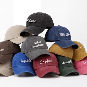 May include: A collection of ten baseball caps in various colors, including black, brown, blue, and pink. Each cap features custom embroidery with names or text like "Eloise," "Sophia," and "Your Logo." The caps are arranged in a visually appealing display.