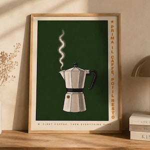 May include: A framed art print featuring a silver stovetop espresso maker with steam rising against a dark green background. The print includes text in gold, reading "PRIMAIL CAFFE, POIIL RESTO" and "FIRST COFFEE, THEN EVERYTHING ELSE."