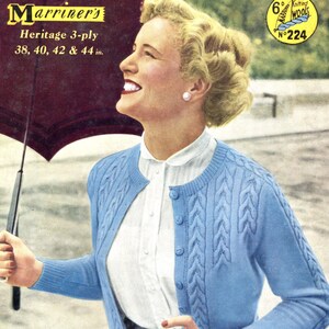 May include: A blue knitted cardigan with a cable knit pattern and button closure. The cardigan is shown on a model wearing a white blouse and a gray skirt. The image includes the text "Marriner's Heritage 3-ply 38, 40, 42 & 44 in."