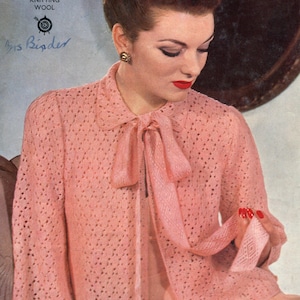 Peut inclure: Un cardigan rose en tricot avec un détail de nœud papillon. Le cardigan est fait avec une laine à tricoter 3 fils et a un motif ajouré. Le texte "TARGET" est visible sur l'image.