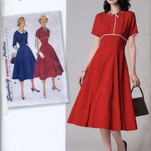 May include: Simplicity sewing pattern 8732 for a 1950s vintage dress. The pattern includes two views: a red dress with white trim and a blue dress with white collar. The pattern is for sizes 16-24.