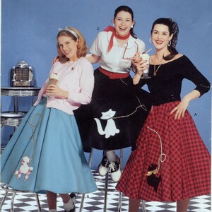 May include: Three women wearing 1950s-style dresses. The woman on the left is wearing a light blue skirt with a poodle design, the woman in the middle is wearing a black skirt with a white cat design, and the woman on the right is wearing a red and black plaid skirt with a black cat design. All three women are holding milkshakes.