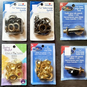 May include: A set of 10 gold 7/16 inch extra-large eyelets and tools for installing them. The eyelets are packaged in a clear plastic bag with a white label that says "7/16" Extra-Large Eyelets" and "Outils pour très grands œillets 1.1cm".
