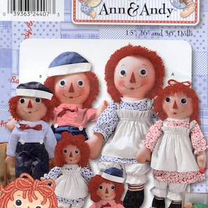 May include: A sewing pattern envelope for Raggedy Ann and Andy dolls in 15, 26, and 36 inch sizes. The cover features illustrations of multiple dolls with red yarn hair, triangular noses, and various outfits including dresses and pants.