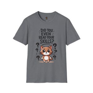 May include: A dark gray t-shirt with a cartoon cat and the text "Did you even read your skills?" printed on the front.