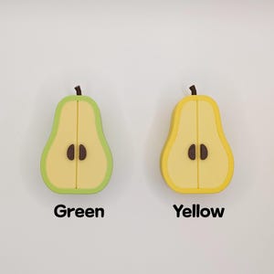 Puede incluir: Dos objetos en forma de pera, uno verde y otro amarillo, cada uno cortado por la mitad para revelar el interior. La pera verde tiene un contorno verde claro y la palabra "Green" debajo. La pera amarilla tiene un contorno amarillo y la palabra "Yellow" debajo.
