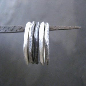 Silver stacking rings in a wavy textured design with mixed metal finish