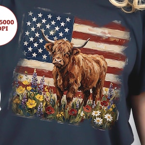 May include: Navy blue t-shirt with a Highland cow design set against a painted American flag. The cow is brown with horns, amidst wildflowers. The shirt has a round neck and short sleeves, suitable for casual wear.