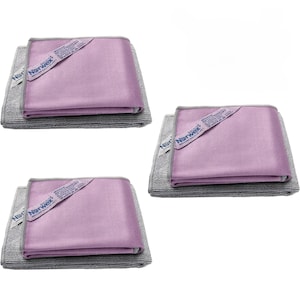 May include: Three sets of folded cleaning cloths, each featuring a smooth, light purple top layer and a textured gray bottom layer. Each purple cloth has a white tag with the Norwex logo and text printed on the corner.