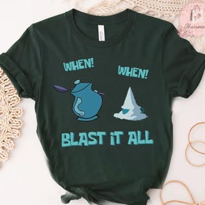 May include: Dark green t-shirt with a whimsical design featuring a blue teapot and a pile of sugar, with the words "WHEN!" and "BLAST IT ALL" in a playful font. A fun, casual tee.