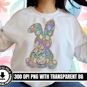 May include: White sweatshirt with a colourful Easter bunny design. The bunny is decorated with pastel-coloured eggs and a bow. The text "300 DPI PNG WITH TRANSPARENT BG" is printed on the bottom of the image.