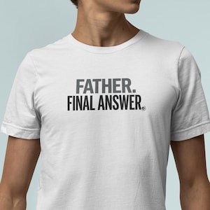 Op de afbeelding: Wit T-shirt met de tekst "FATHER. FINAL ANSWER." in grijs gedrukt. Het T-shirt wordt gedragen door een persoon in een spijkerbroek. De tekst staat in het midden op de borst.
