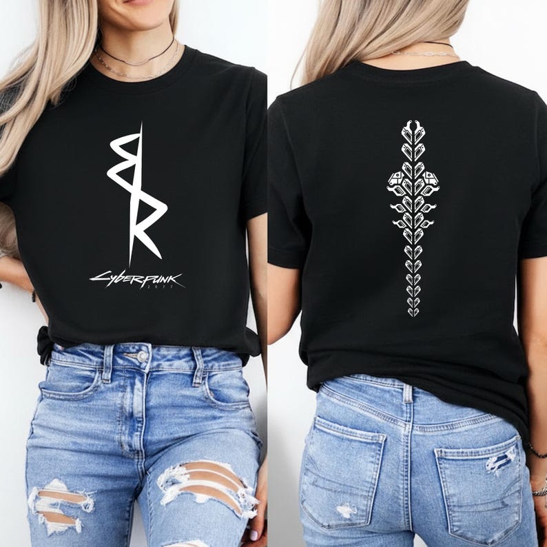 May include: Black t-shirt with a white graphic on the front and back. The front graphic is a stylized design with the word "CYBERPUNK" below it. The back features a vertical floral design. The shirt is paired with blue jeans.