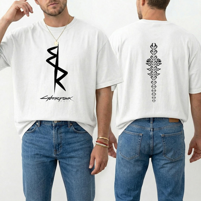 May include: White t-shirt with a black graphic on the front and back. The front features a stylized design with the word "Cyberpunk" below. The back has a vertical floral design. The shirt is worn with blue jeans.