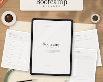 May include: A digital tablet displaying a Bootcamp Planner cover page, surrounded by printed planner sheets including goal setting, weekly meal planning, and habit tracking pages, with a black pen and coffee cups nearby.