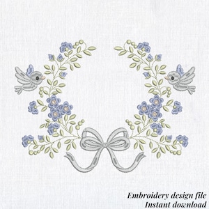 May include: An embroidery design featuring a wreath of blue flowers and green leaves, with two gray birds and a gray bow at the bottom. The text "Embroidery design file Instant download" is at the bottom.