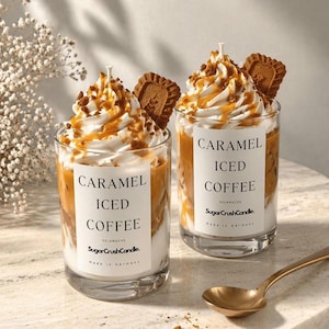 Könnte beinhalten: Zwei Glaskerzen im Design von Eiskaffee mit Karamell, garniert mit weißer Wachs-Schlagsahne, Karamellsirup und einem Keks. Jede Kerze hat ein weißes Etikett mit der Aufschrift CARAMEL ICED COFFEE, SOJAWACHS, SugarCrushCandle, Made in Germany.