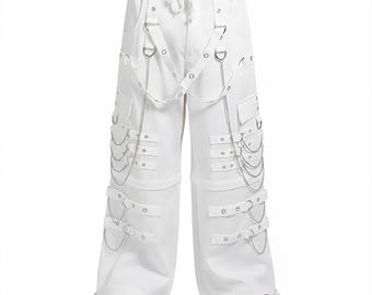 May include: White wide-leg pants with multiple straps, metal chain accents, and D-ring details. The pants have a drawstring waist and pockets. The pants are paired with black shoes.
