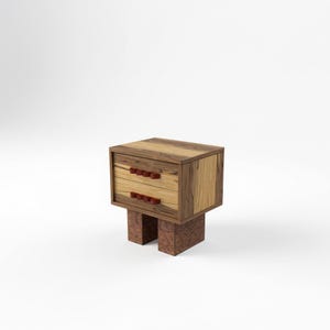 May include: A compact, two-drawer wooden bedside table with a light and dark wood grain finish. The drawers feature small, round, reddish-brown handles. The table stands on a patterned, reddish-brown base.