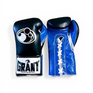 以下が含まれることがあります： 黒と青のボクシンググローブのペア。黒いグローブには白いロゴと「GRANT」の文字が長方形のパッチにあります。青いグローブには白いレースが付いています。
