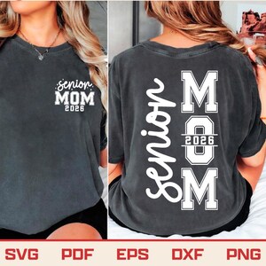 May include: Dark gray t-shirt with the text "senior MOM 2026" on the front and the word "Senior" vertically down the back, with "MOM 2026" in a block letter design. The shirt is a casual style.