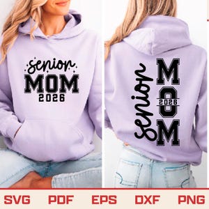 May include: A light purple hoodie with the text "Senior MOM 2026" on the front and back. The front design features the words in a black, bold font with decorative stars. The back design has the word "Senior" vertically and "MOM 2026 M" in a block letter style.