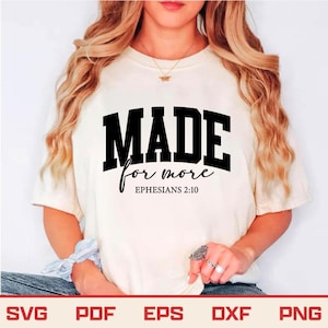 May include: Cream-colored t-shirt with the text "MADE for more" in black block letters and script. Below the text is "Ephesians 2:10". The shirt is a casual style.