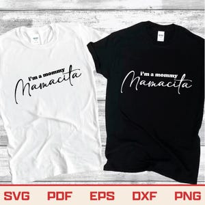 May include: Two t-shirts, one white and one black, with the text "I'm a mommy Mamacita" in a cursive font. The shirts are short-sleeved and have a crew neck. Below the shirts are the words SVG, PDF, EPS, DXF, and PNG.