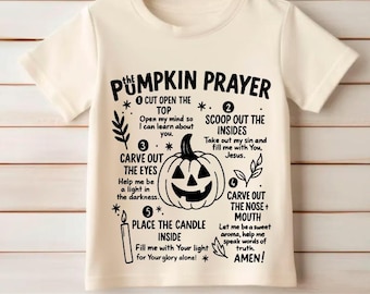 May include: Off-white t-shirt featuring the text "The Pumpkin Prayer" with instructions for carving a jack-o'-lantern. The design includes a pumpkin graphic and step-by-step text instructions. The bottom of the shirt displays file type options.