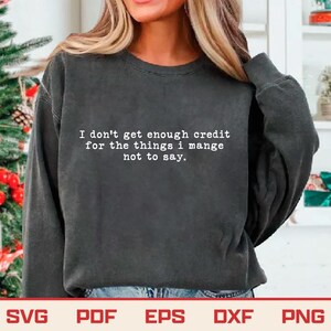 May include: Dark gray sweatshirt with the text "I don't get enough credit for the things I manage not to say" in white. The bottom of the image shows the file types: SVG, PDF, EPS, DXF, and PNG.