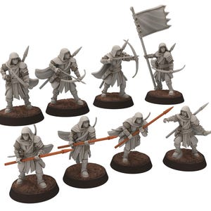 Może przedstawiać: Zestaw ośmiu niepomalowanych figurek miniaturowych przedstawiających postaci w kapturze z łukami i strzałami, niektóre trzymające włócznie. Figurki stoją na okrągłych podstawach.