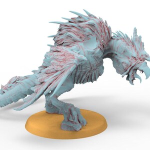 May include: A light blue and red fantasy creature figurine with a bird-like appearance. The figurine has a detailed, textured surface and is posed on a small, round, yellow base. The creature has sharp claws and a beak.
