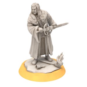 Puede incluir: Una figurita pintada de blanco de un hombre que lleva una capa forrada de piel y sostiene una espada. La figurita está de pie sobre una base redonda con un borde amarillo.