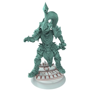 Puede incluir: Figura de color turquesa de un guerrero con armadura ornamentada, sosteniendo una espada. La figura se encuentra sobre una base circular con detalles grabados. El guerrero tiene un casco con una cresta alta y puntiaguda y cabello suelto.