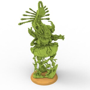 May include: A green fantasy figurine of a creature with multiple arms and a large head, standing on a round base. The figurine has intricate details and a stylized design, with a light brown base.