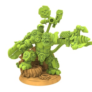 Puede incluir: Una figura en miniatura verde de un personaje parecido a un orco, fuertemente blindado, empuñando una gran espada y un arma futurista. La figura tiene un bastón con una calavera y está montada sobre una base marrón con engranajes y un neumático.