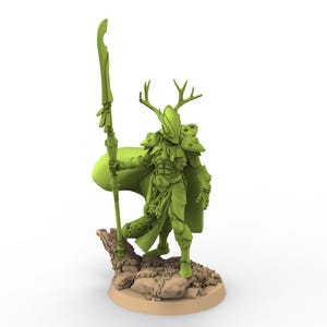 Pode incluir: Uma estatueta verde de um personagem de fantasia com chifres, armadura e capa, segurando uma vara. A figura está sobre uma base rochosa com uma plataforma circular bege. O design sugere um guerreiro ou criatura mítica.