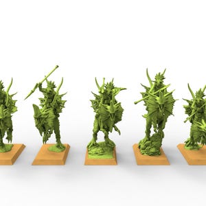 以下が含まれることがあります： 槍や武器を持った、トカゲのような生き物が恐竜のような乗り物に乗っている、緑色のファンタジーミニチュアが5体。フィギュアは茶色の長方形の台座にあり、白い背景に配置されています。 テーブルゲーム用です。