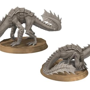 以下が含まれることがあります： 質感のある鱗ととげのあるひれを持つ、2体のグレーのプラスチック製のミニチュアドラゴンフィギュア。ドラゴンは、丸い茶色の土台の上に異なるポーズをとっています。