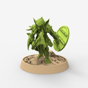 May include: A green fantasy miniature of a goblin warrior, holding a shield and a weapon. The goblin is standing on a base with rocks and skulls. The miniature is highly detailed and suitable for tabletop gaming or collecting.