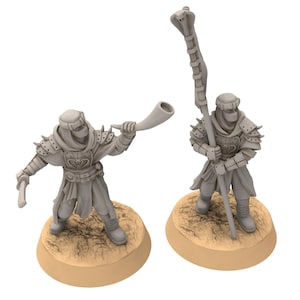 May include: Two gray miniature figures of warriors, each standing on a tan base. One figure holds a horn and a curved blade, the other holds a staff with a cobra head. Both figures wear armor and head coverings.