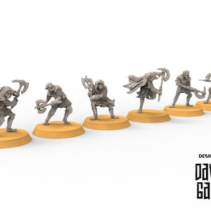 Puede incluir: Seis figuras en miniatura de guerreros de fantasía, cada uno posando con un arma, incluyendo hachas y una ballesta. Las figuras son grises y están sobre bases redondas y beige. El texto "DESIGNED BY DAVALE GAMES" está impreso en negro.