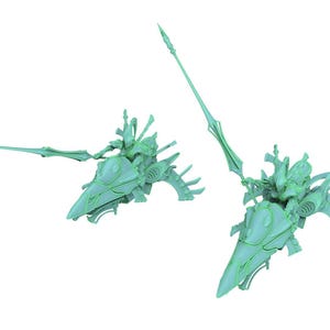 May include: Two light mint green miniature figurines depicting armored riders mounted on sleek, aerodynamic vehicles. Each rider holds a long, pointed lance extending forward, while the vehicles feature curved, fin-like structures at the rear.