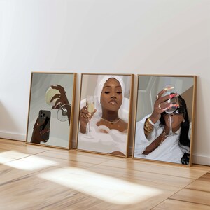 May include: Three framed art prints featuring illustrations of women enjoying champagne. One print shows a woman taking a selfie with a glass, another in a bathtub, and the third holding a glass with long nails.
