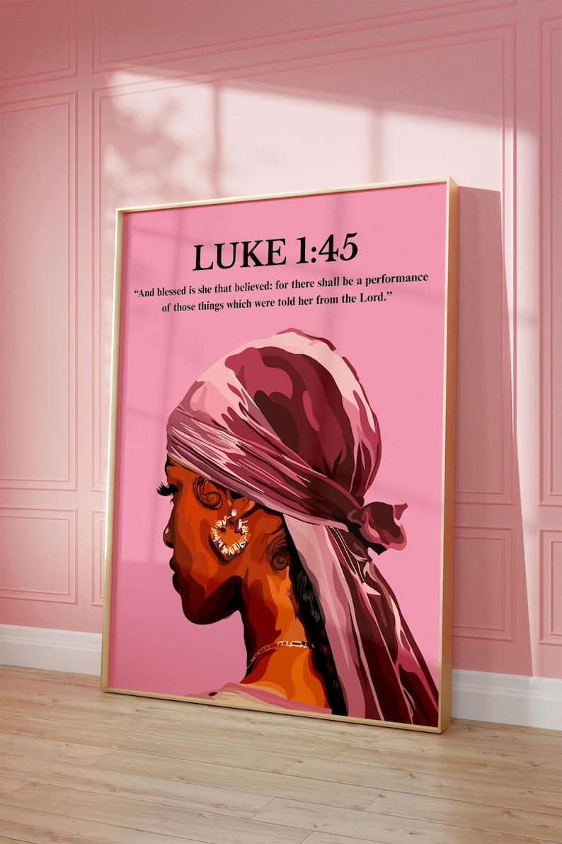 May include: A framed art print featuring a side profile of a person wearing a headscarf and hoop earrings. The artwork is set against a pink background and includes the text "LUKE 1:45" and a Bible verse.